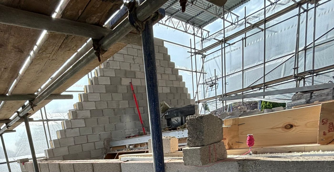 Blockwork gable rising under scaffolding, Aberdare